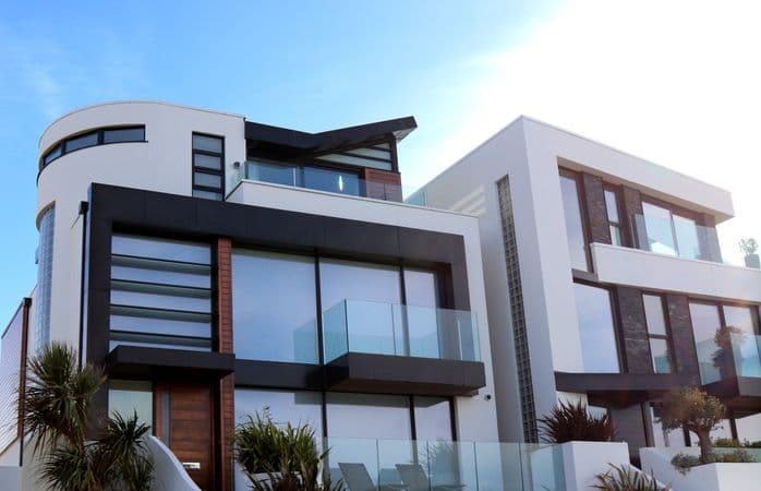 Moderne energiezuinige nieuwbouwwoning in Vlaanderen met zonnepanelen op het dak en warmtepomp in de tuin